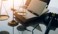 Libro jurídico junto a un mazo de juez y balanza Libro jurídico junto a un mazo de juez y balanza